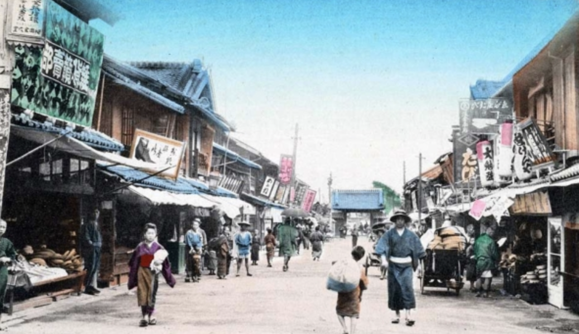 A colorized street in a Japanese town, date unknown. 